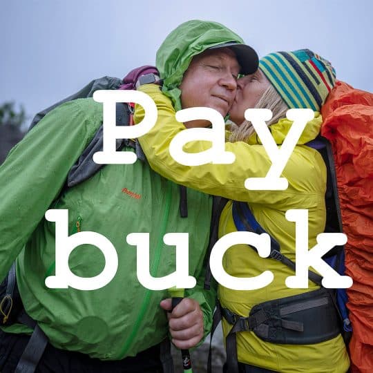 En kvinna i friluftskläder pussar en man på kinden och texten pay Buck